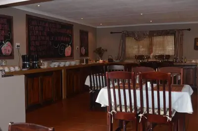 a restaurant with a table and chairs and a bar at Mon Repos Guest Farm in Bela-Bela