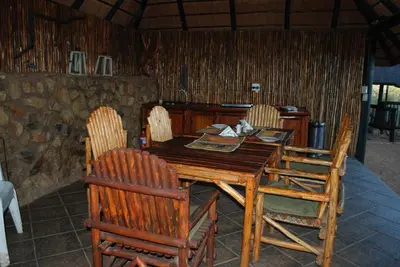 a wooden table and chairs in a room at Adansonia Eco Lodge in Musina