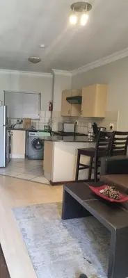a kitchen and living room with a table and chairs at Premium Getaway @ la Bella Costa in Pretoria