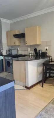 a kitchen with a counter and a table in a room at Premium Getaway @ la Bella Costa in Pretoria