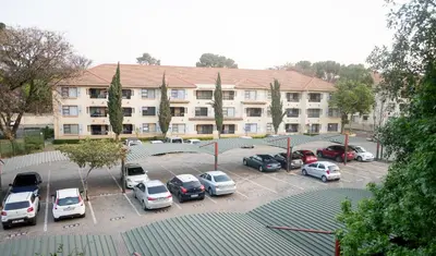 a parking lot with cars parked in front of a building at Premium Getaway @ la Bella Costa in Pretoria