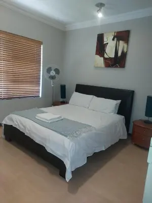 a bedroom with a bed and a fan at Premium Getaway @ la Bella Costa in Pretoria