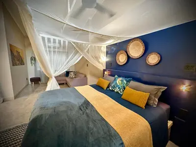 a bedroom with a bed and two clocks on the wall at Geelslang Paradise - Kruger Park in Marloth Park