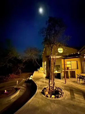a house with a tree in a courtyard at night at Geelslang Paradise - Kruger Park in Marloth Park