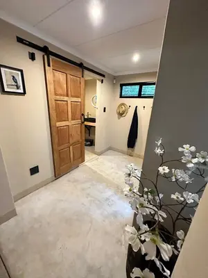 a hallway with a door and a vase with flowers at Geelslang Paradise - Kruger Park in Marloth Park