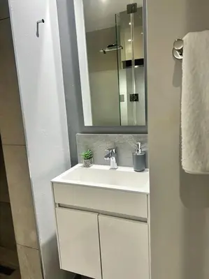 a bathroom with a white sink and a mirror at Apartments at Brooklyn/Waterkloof in Pretoria