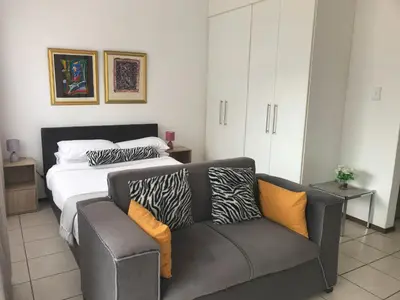 a bedroom with a bed and a couch at Studio Eazi in Midrand
