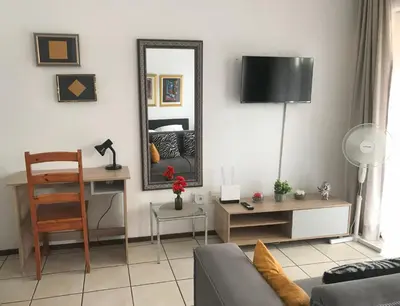 a living room with a mirror and a couch at Studio Eazi in Midrand