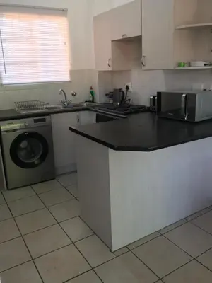 a kitchen with a sink and a washing machine at Studio Eazi in Midrand
