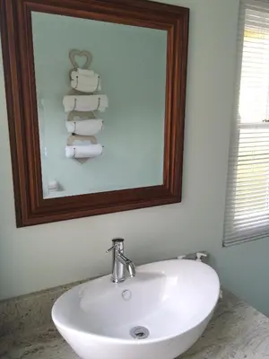 a bathroom with a sink and a mirror and towels at The Rose Cottage B&B in Dullstroom