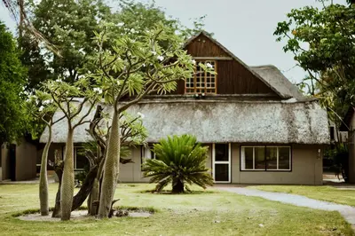 a house with trees in front of it at Unyati Safari Lodge in Hectorspruit