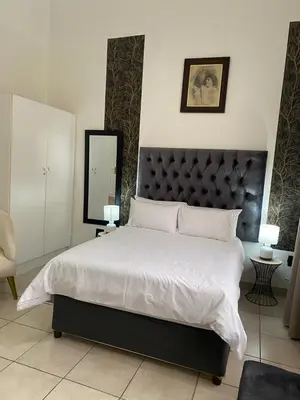 a bedroom with a large bed with a large headboard at Ditoro Boutique Hotel in Pretoria