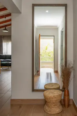 a mirror on the wall in a living room with a stool at Utopia on the Rock1 in Nelspruit