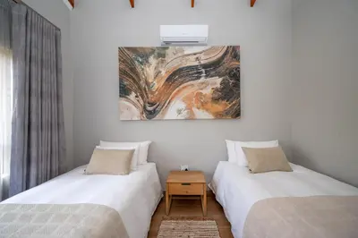two beds in a room with a painting on the wall at Utopia on the Rock1 in Nelspruit