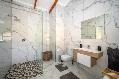 a bathroom with a shower and a toilet and a sink at Utopia on the Rock1 in Nelspruit