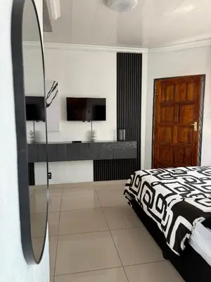 a bedroom with a bed and a television in it at Studios at Monarch Inn in Polokwane
