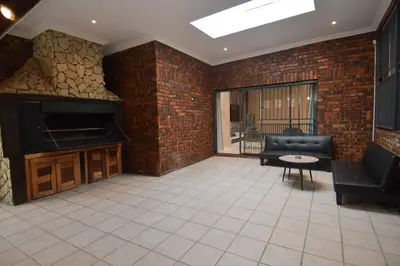 a large living room with a brick wall at Menlyn Maine - The Smart Home in Pretoria