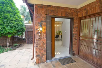 a brick house with an open door with a hallway at Menlyn Maine - The Smart Home in Pretoria