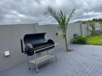 a grill sitting on a patio next to a wall at Maison De luxe in Thohoyandou