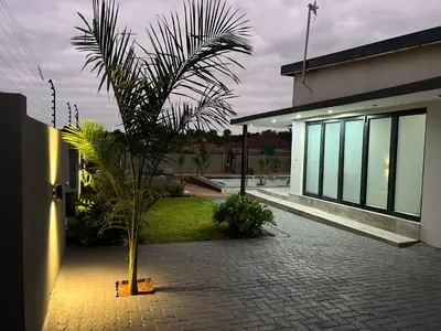 a palm tree in front of a house at Maison De luxe in Thohoyandou