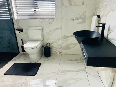 a bathroom with a black sink and a toilet at Maison De luxe in Thohoyandou