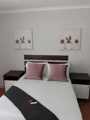 a bedroom with a large white bed with two tables at 473 On Cliff in Pretoria