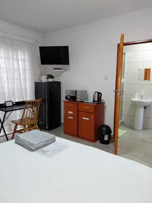 a room with a kitchen with a refrigerator and a table at The Affectionate One in Louis Trichardt