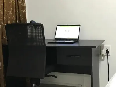 a laptop computer sitting on a desk with a chair at The Affectionate One in Louis Trichardt