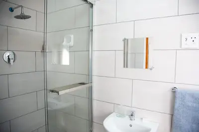 a white bathroom with a sink and a shower at The Affectionate One in Louis Trichardt