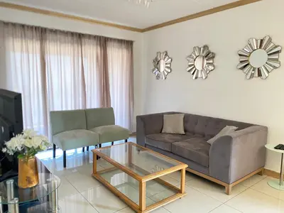 a living room with a couch and a coffee table at Siena Sun Luxury Apartment 6 in Midrand