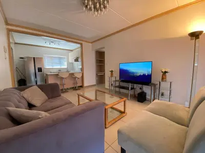 a living room with two couches and a flat screen tv at Siena Sun Luxury Apartment 6 in Midrand