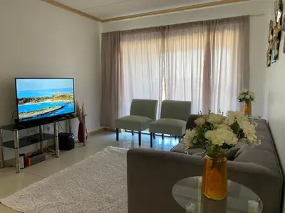 a living room with a couch and a television at Siena Sun Luxury Apartment 6 in Midrand
