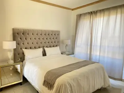 a bedroom with a large bed and a window at Siena Sun Luxury Apartment 6 in Midrand