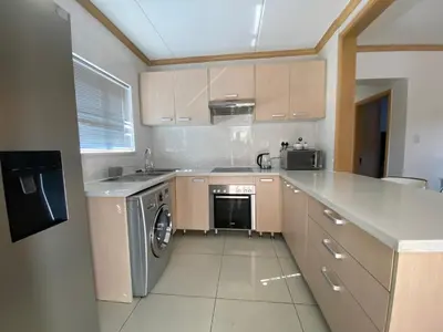 a kitchen with a washer and a dishwasher at Siena Sun Luxury Apartment 6 in Midrand