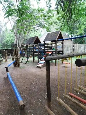 a playground with a blue baseball bat and swings at Kruger Maroela Lodge in Marloth Park