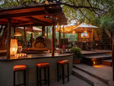 an outdoor bar with stools at a restaurant at Kruger Maroela Lodge in Marloth Park