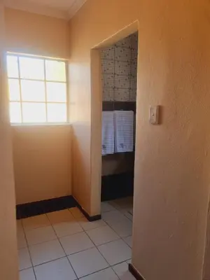 a bathroom with a window and a walk in shower at Home Life Guesthouse in Midrand