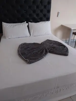a blanket on a white bed with a black headboard at Home Life Guesthouse in Midrand