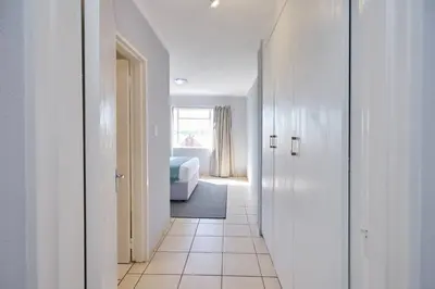a hallway with a room with a bed and a room with white walls at Unit 309 at Menlyn Place in Pretoria