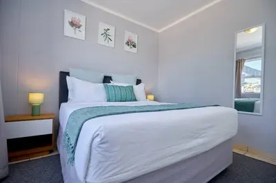 a white bedroom with a large bed and a window at Unit 309 at Menlyn Place in Pretoria