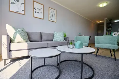 a living room with two tables and a couch at Unit 309 at Menlyn Place in Pretoria