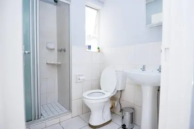 a bathroom with a toilet and a sink and a shower at Unit 309 at Menlyn Place in Pretoria