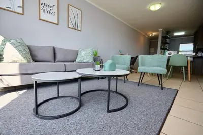 a living room with two tables and a couch at Unit 309 at Menlyn Place in Pretoria