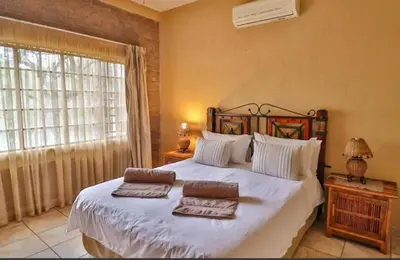 a bedroom with a large bed with two towels on it at Mispel House self catering holiday accommodation in Komatipoort