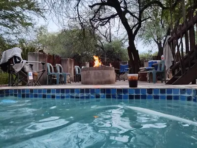 a swimming pool with a fire in a yard at Mispel House self catering holiday accommodation in Komatipoort