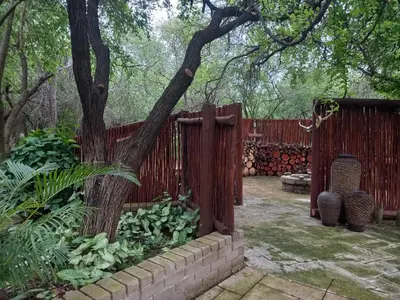 a fence and a tree in a yard at Mispel House self catering holiday accommodation in Komatipoort