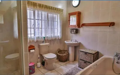 a bathroom with a toilet and a sink and a tub at Mispel House self catering holiday accommodation in Komatipoort
