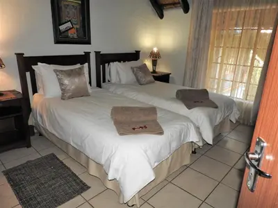 a bedroom with two beds with towels on them at Mispel House self catering holiday accommodation in Komatipoort