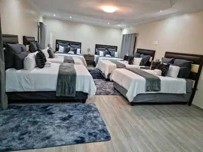 a group of four beds in a room at Lasev Resort in Pretoria