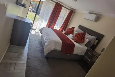 a bedroom with a large bed in a room with a window at Lasev Resort in Pretoria